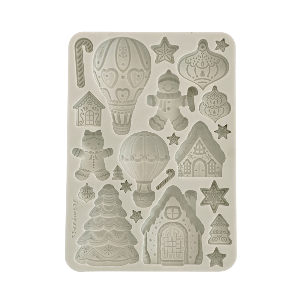 A rectangular silicone mold with Christmas-themed embossed designs, including gingerbread houses, hot air balloons, candy canes, stars, and a gingerbread person.