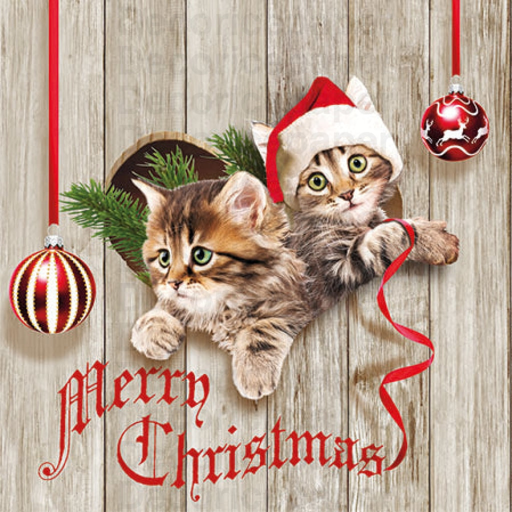 A paper napkin featuring an illustration of two kittens wearing Santa hats, with a 'Merry Christmas' text, and decorative elements like Christmas balls and a Christmas tree in the background.