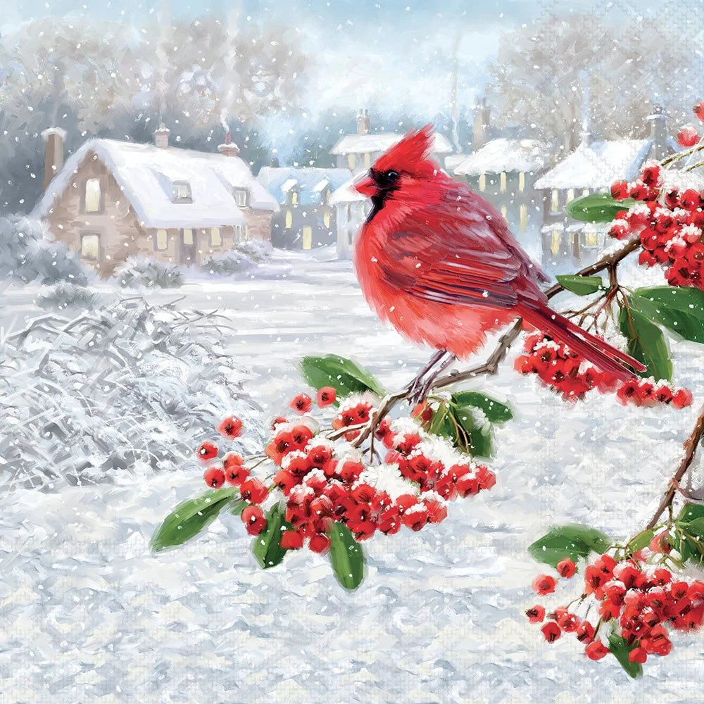 A winter village scene with snow-covered houses in the background and a bright red cardinal perched on a branch with clusters of red berries and green leaves in the foreground.