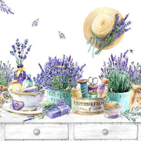 Decorative scene with lavender, a straw hat, and various items on a white surface.