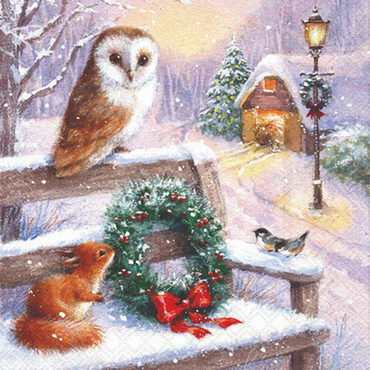 Owl,squirrel, and birds on a snowy bench with a Christmas wreath.
