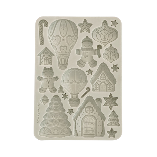 A rectangular silicone mold with Christmas-themed embossed designs, including gingerbread houses, hot air balloons, candy canes, stars, and a gingerbread person.