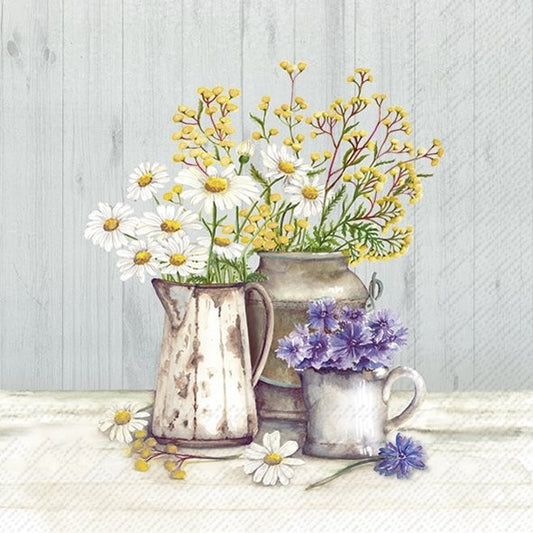 Three rustic vases with flowers on a wooden surface against a light gray background