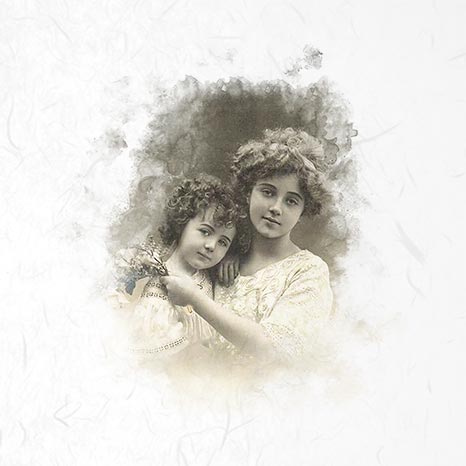 Vintage photograph of two young girls with curly hair, holding a bouquet.